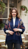 Woman wearing a blue patterned shawl in an outdoor cafe setting