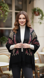 Woman wearing a black floral-patterned shawl in an outdoor setting