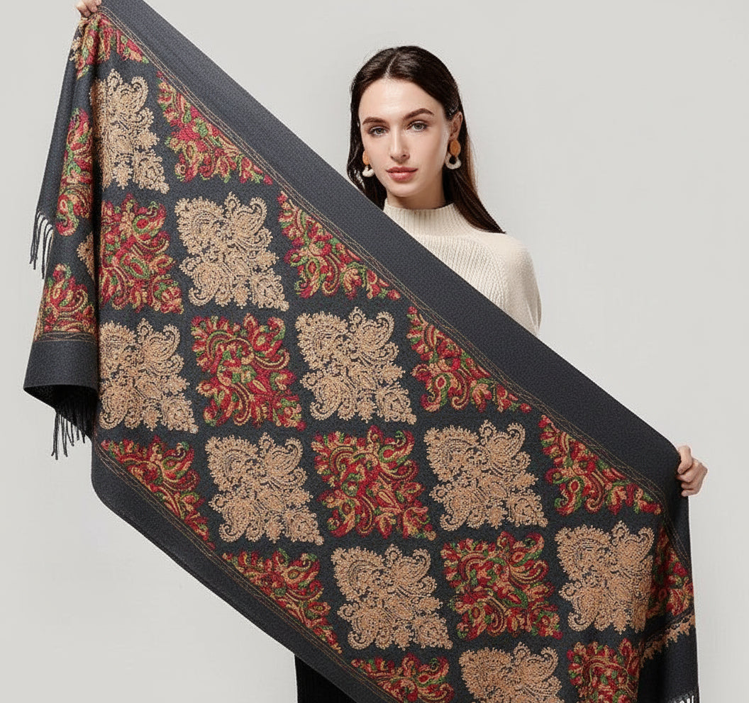 Woman holding a decorative scarf with intricate patterns on a plain background